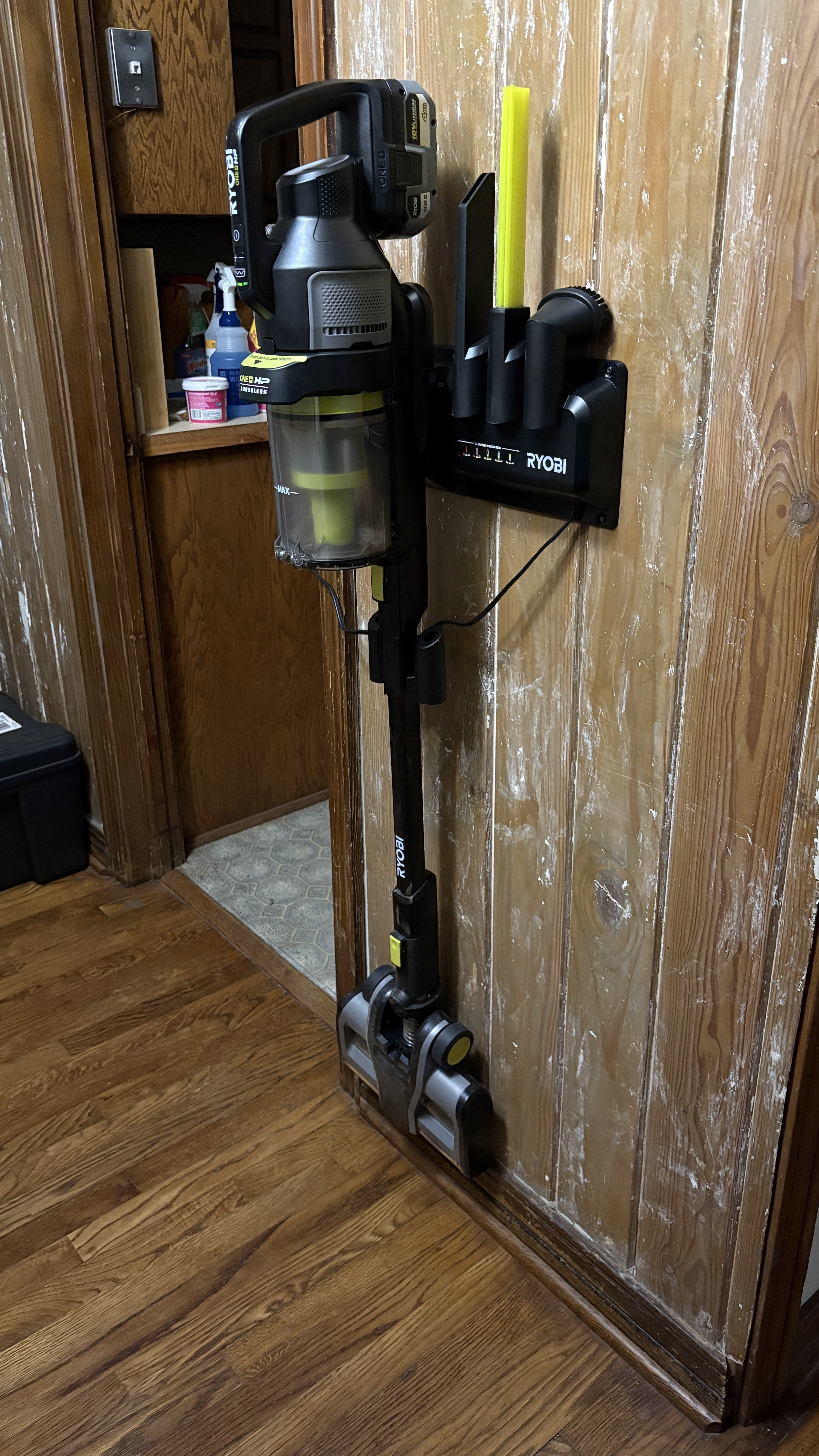 A Ryobi PBLSV719 Stick Vacuum mounted to a wood wall